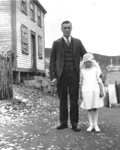 154: J V McCarthy and his daughter Mollie in her First Communion dress. Jer Ryan's house at left  (family had moved to Grand Falls). (circa 1928)  - J V son of Thomas McCarthy &amp;amp; Anastasia Fitzgerald